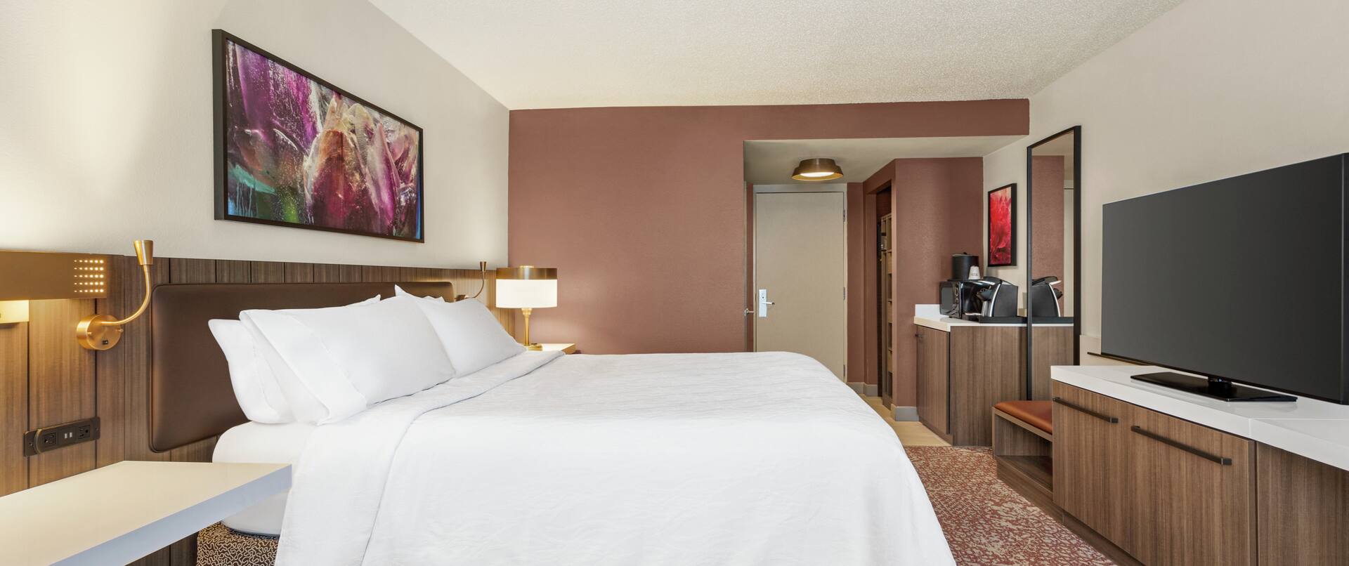 Spacious guest room featuring comfortable king bed and TV.