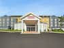 Welcoming Hilton Garden Inn hotel exterior featuring eye-catching design, lush landscaping, and blue sky.