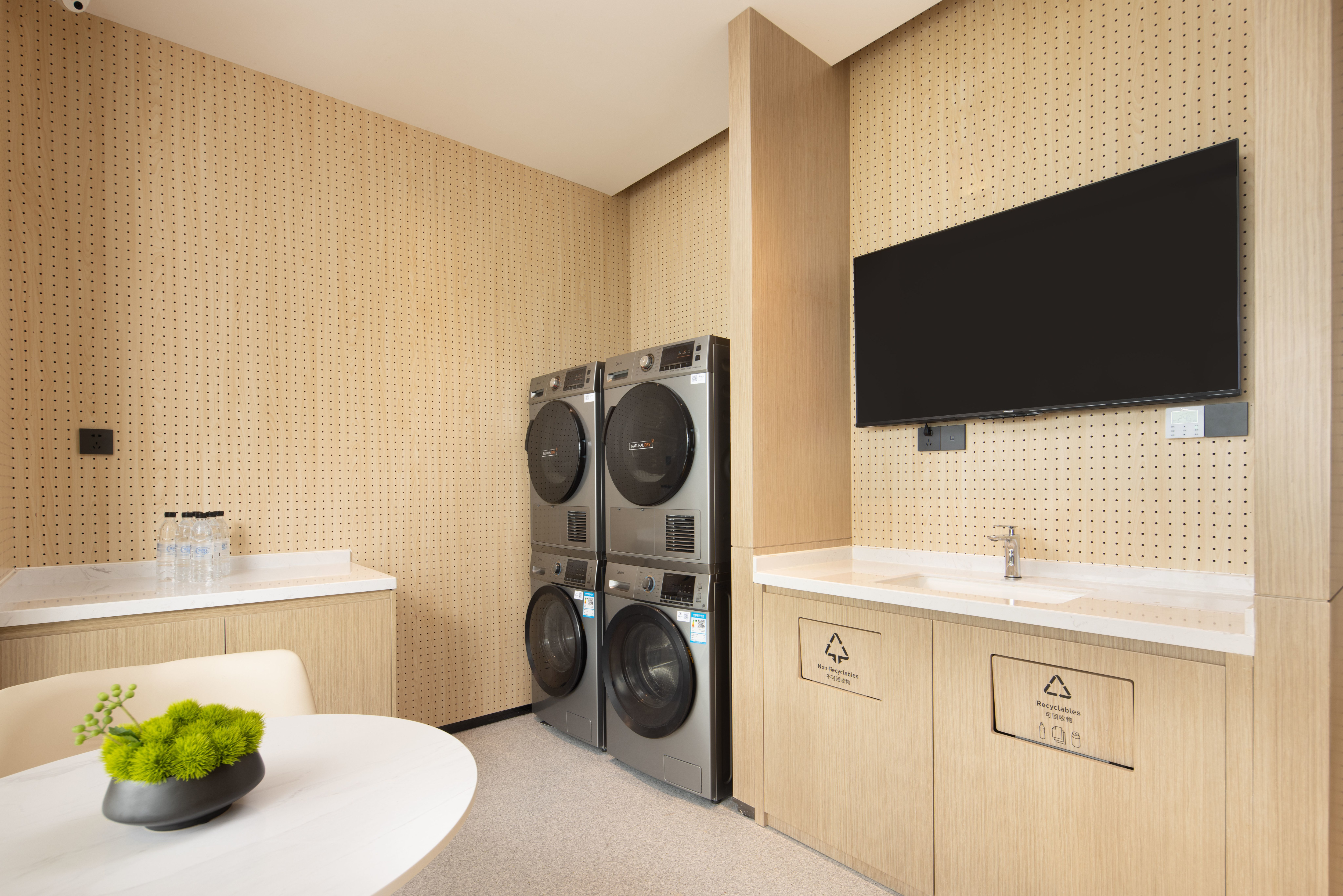 Laundry room with washing machines and wall mounted TV