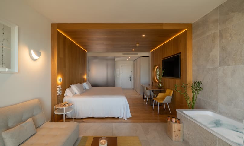 Loungebereich und Badewanne im Schlafzimmer mit Kingsize-Bett, nächster Übergang