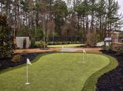 3-Hole Putting Green On-Site Surrounded by Trees With Vies of Life-Size Chess Board in Background
