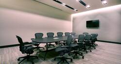 Meeting Room with Oval Table, Office Chairs and Wall Mounted HDTV