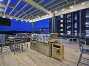 Outdoor Patio at Night with Two Grills and Seating