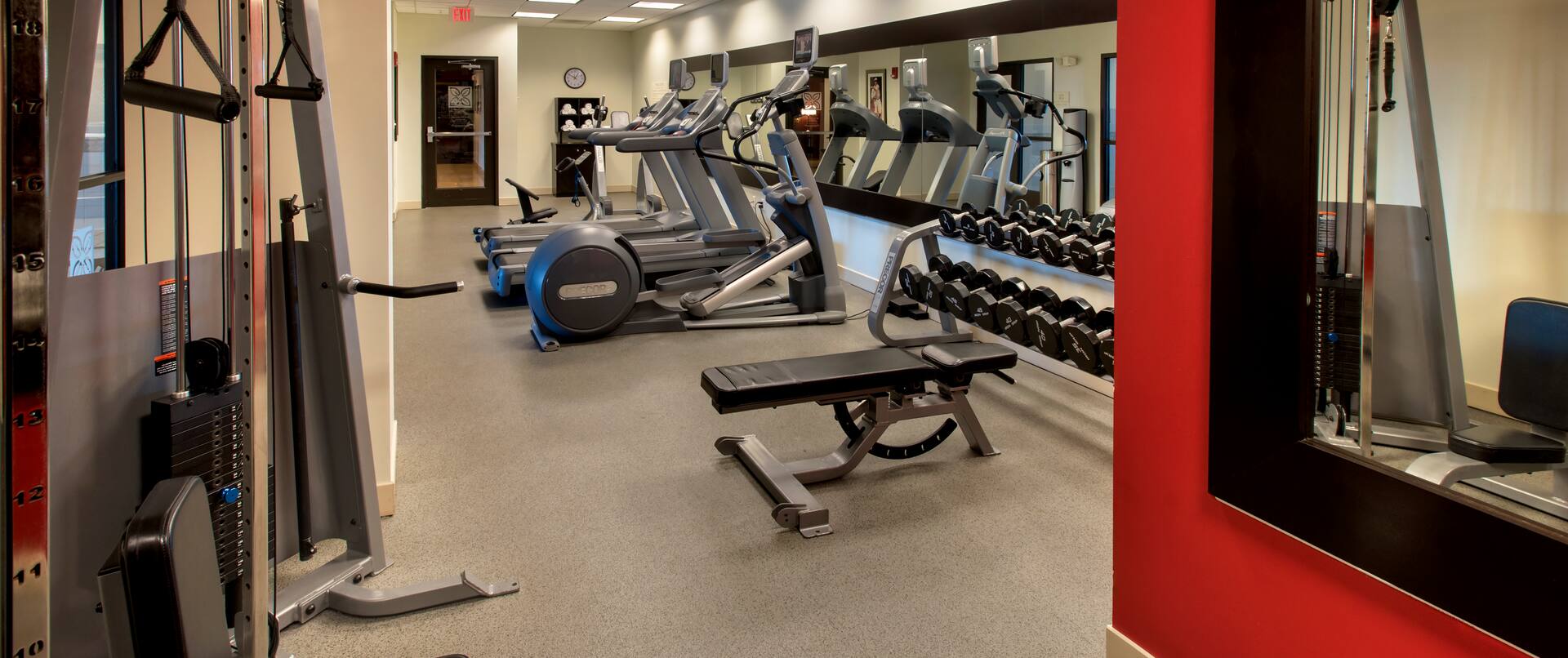 Gym with treadmills, weights, and other equipment.