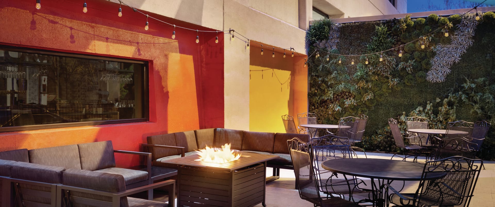 Outdoor Patio Seating Area with Sofas, Firepit, Chairs and Table at Dusk