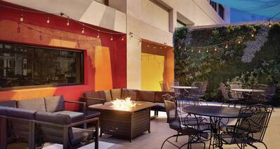 Outdoor Patio Seating Area with Sofas, Firepit, Chairs and Table at Dusk