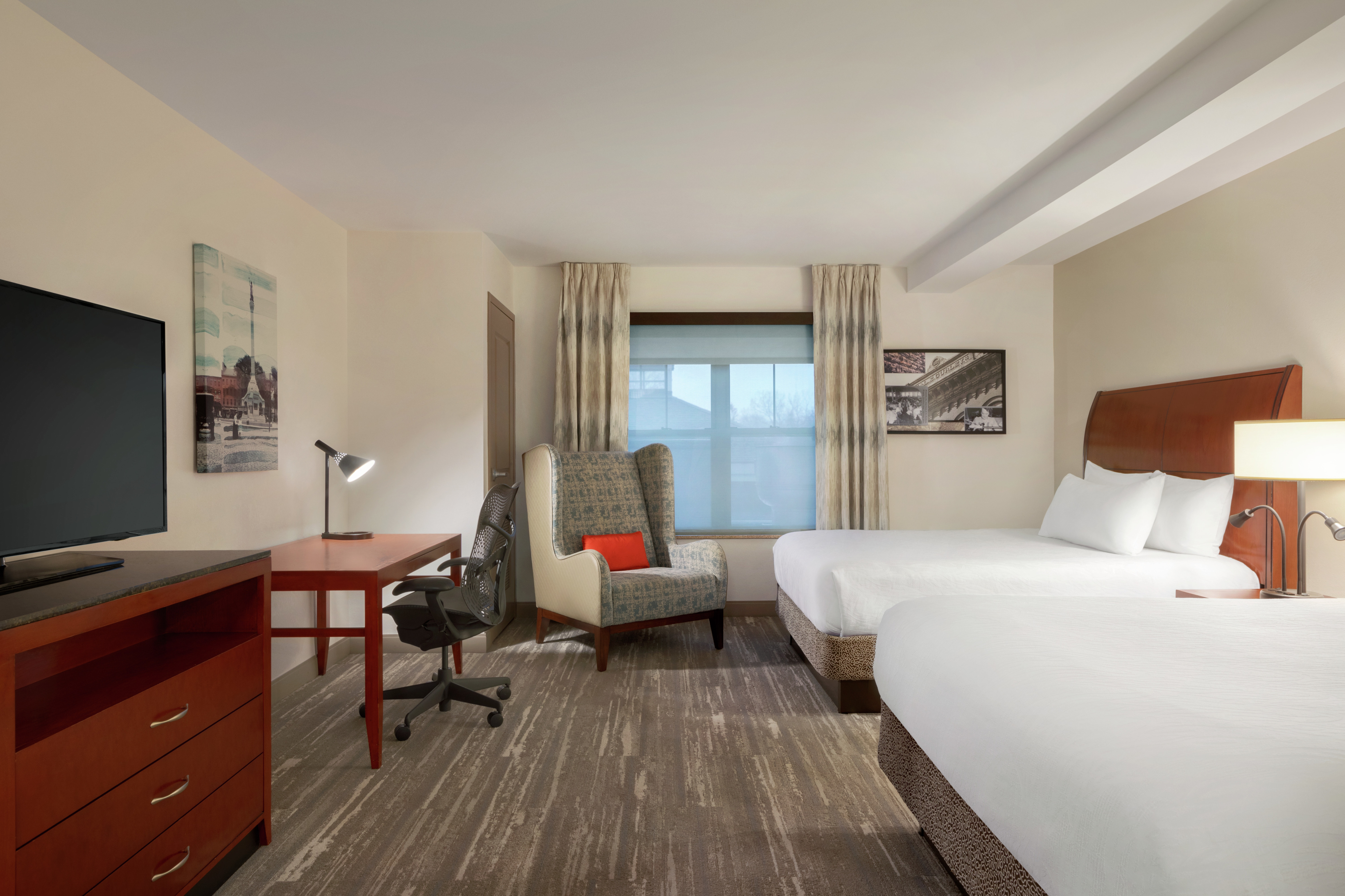 Spacious accessible guestroom featuring TV, work desk, and two comfortable queen beds.