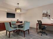 Bright premium guestroom featuring wet bar, dining table, and work desk with ergonomic chair.