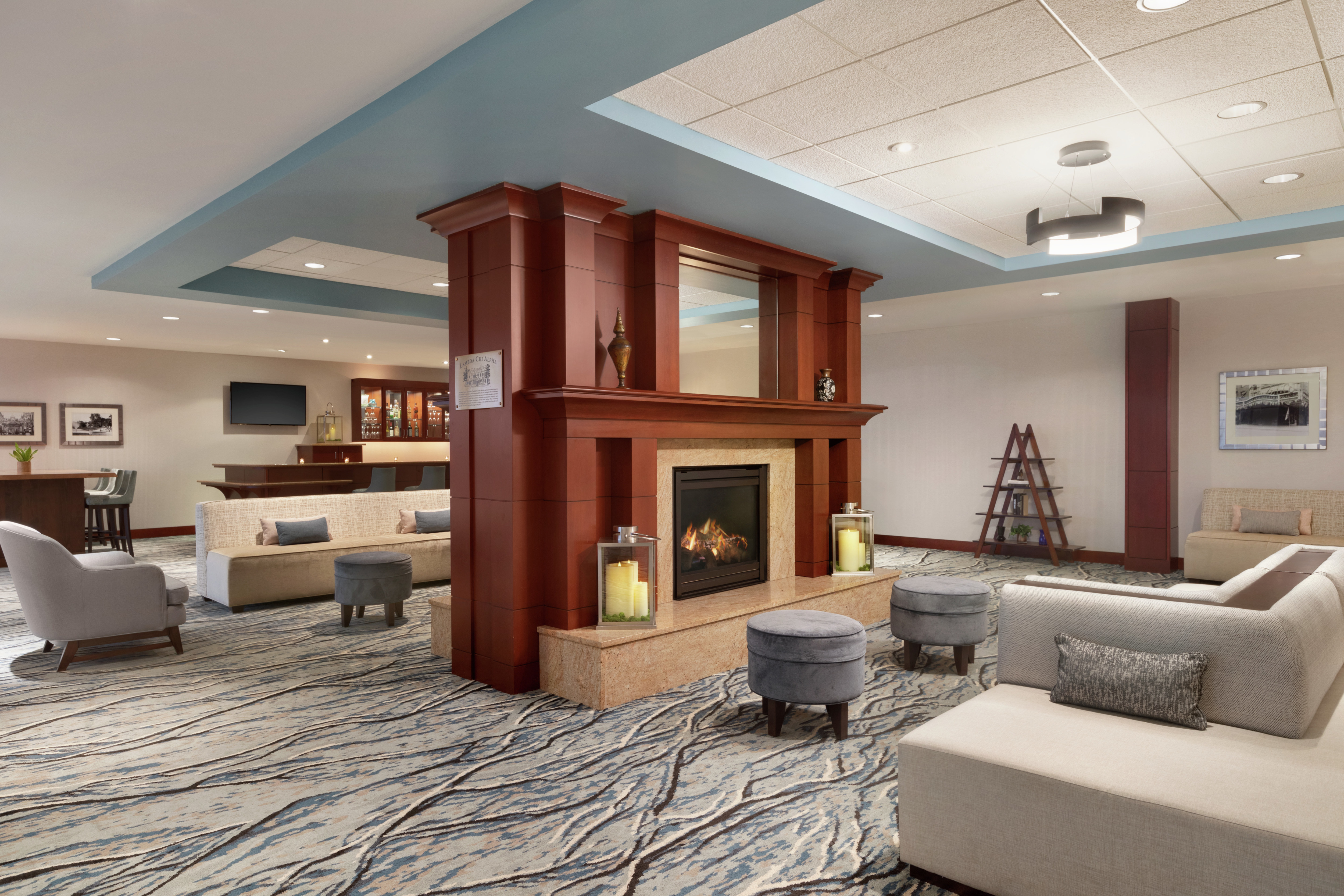 Stunning hotel atrium featuring comfortable seating, large fireplace, and bar.