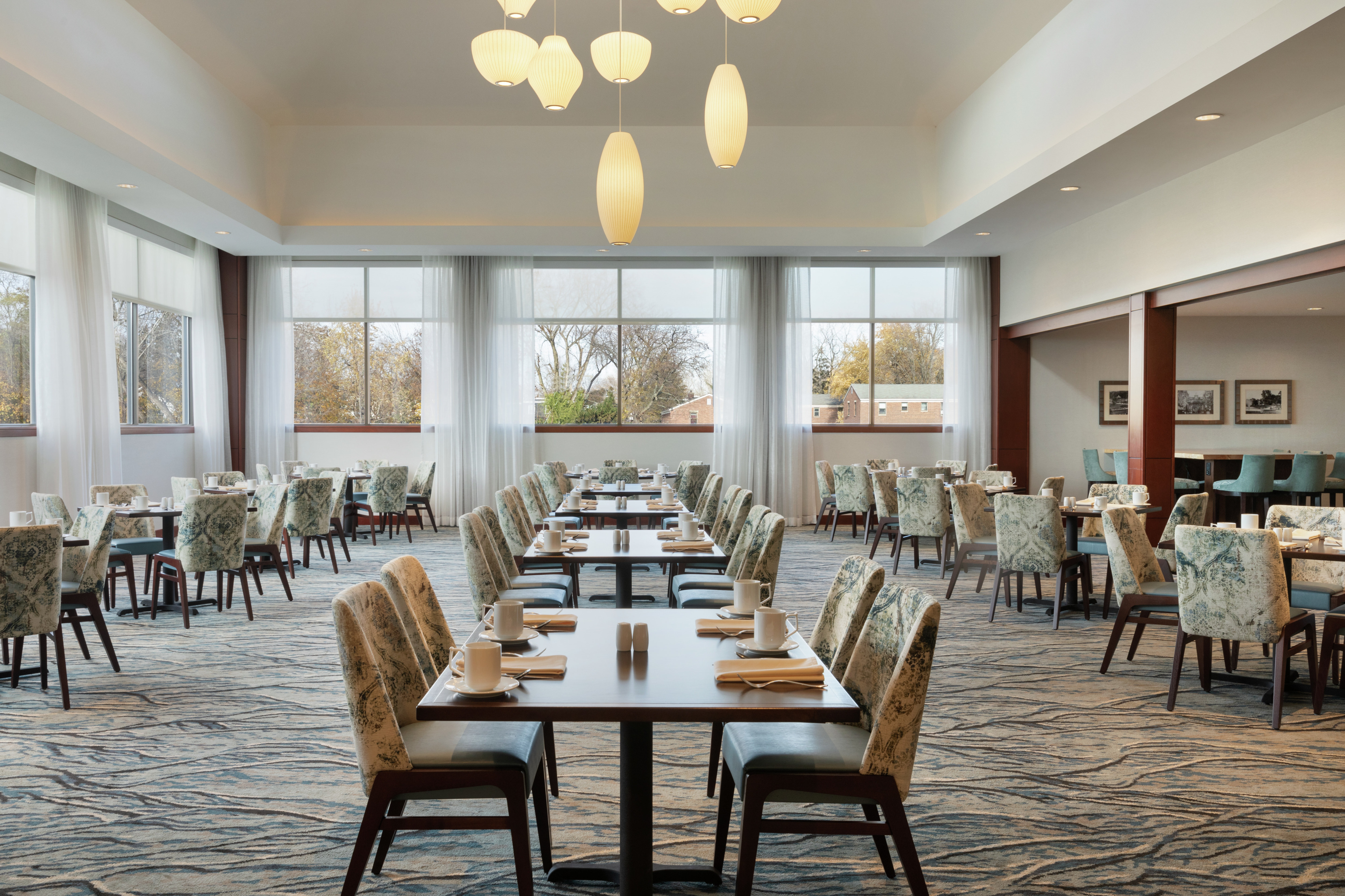 Bright breakfast area featuring ample seating, outside views, and stunning light fixture.