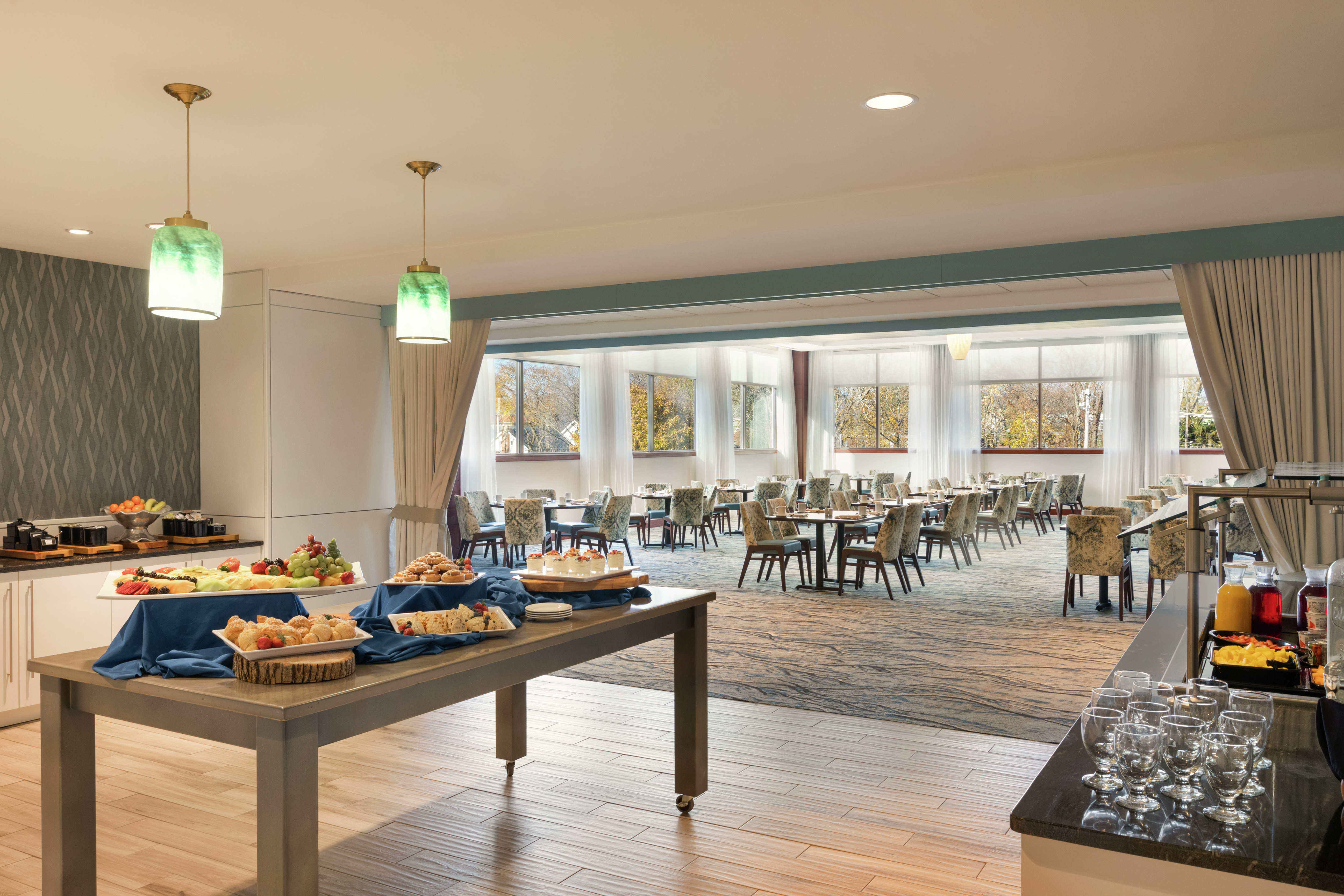 Bright breakfast area featuring complimentary buffet for guests and ample seating.