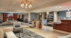Spacious hotel lobby featuring comfortable seating area, front desk, and convenient snack shop.
