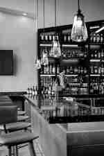 Bar se stoličkami a lampami