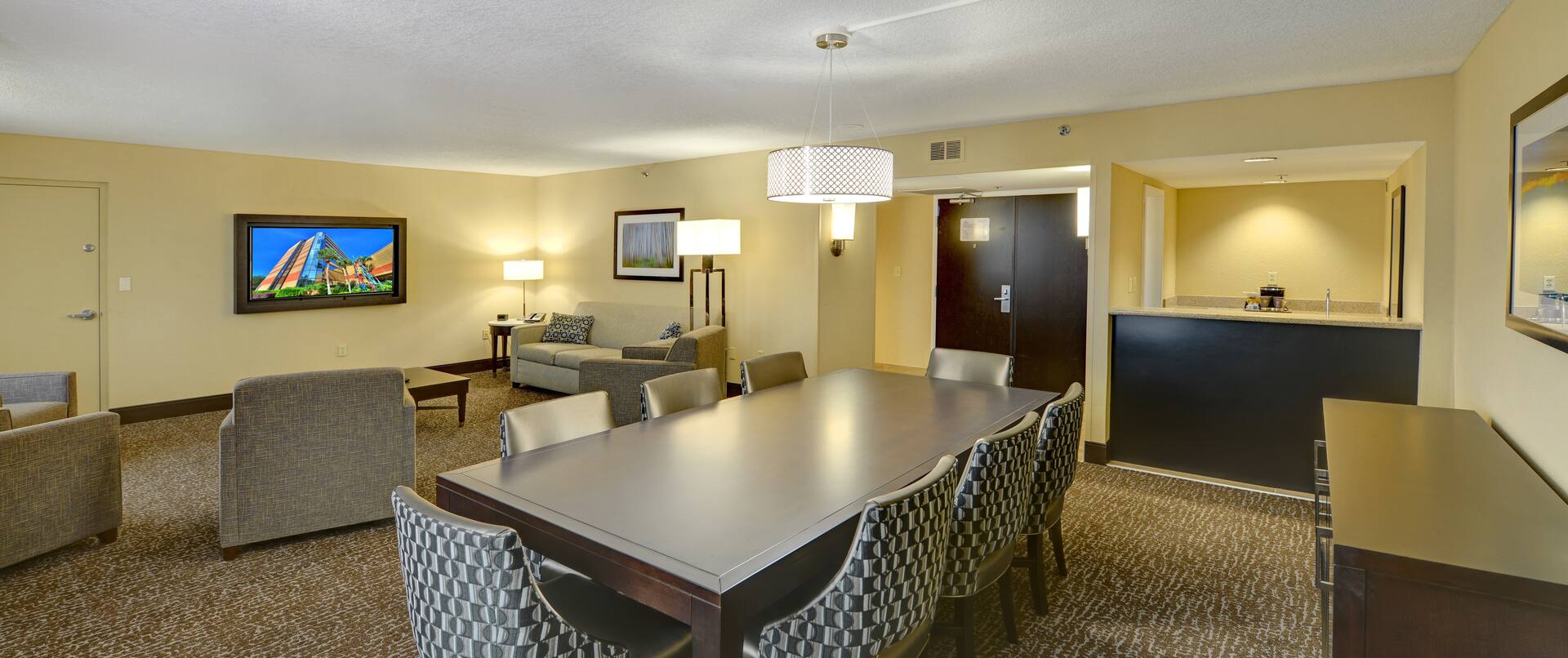 Guest Suite Lounge Area with Chairs, Table and Wall Mounted HDTV