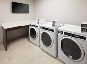 Guest Laundry Room with Coin-Operated Washing Machines and Wall Mounted HDTV