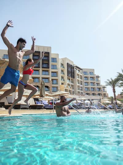 Friends Jumping in Infinity Pool