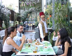 Nasma Beirut restaurant, with group of people sitting around a table being served by waiting staff