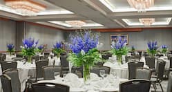 Ballroom Decorated with Blue Flowers on Round Tables with White Tablecloths