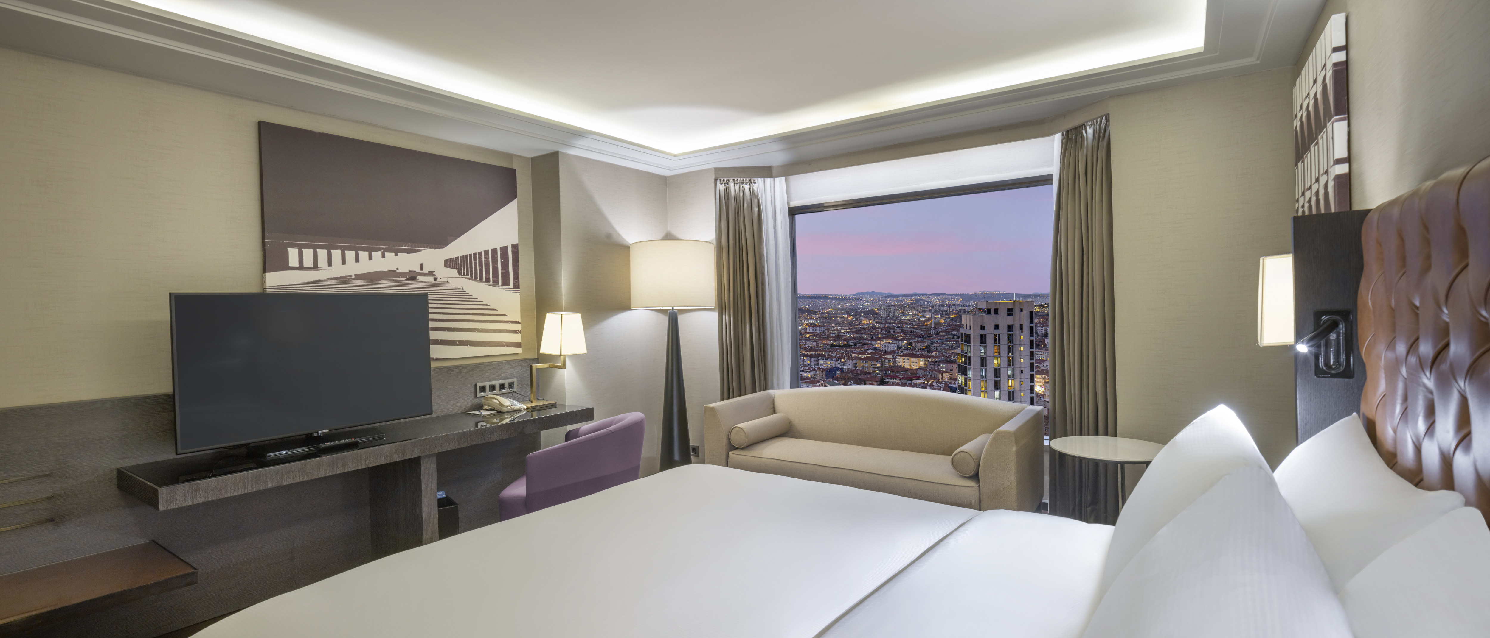 Suite Bedroom with Large Bed HDTV Sofa and City View