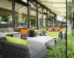 Hilton Antwerp Old Town – Terrasse mit Stühlen und Tischen, gedeckt mit Weingläsern