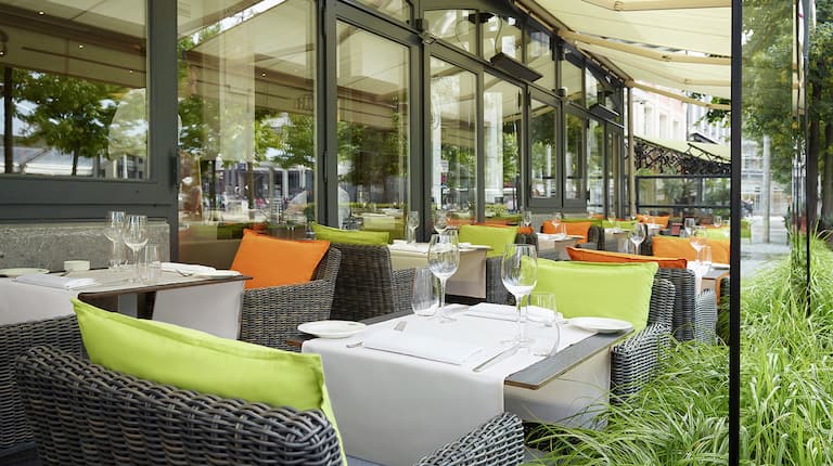 Terrasse extérieure, chaises et tables avec verres de vin à l'hôtel Hilton Antwerp Old Town
