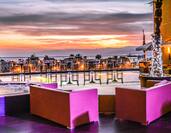 Infinity Chill Out Area With Lounge Seating by Hot Tub Illuminated in Pink Lights at Sunset