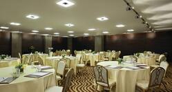 Pine Tree Meeting Room Set Up With Round Tables With Cream Colored Cloths and Podium