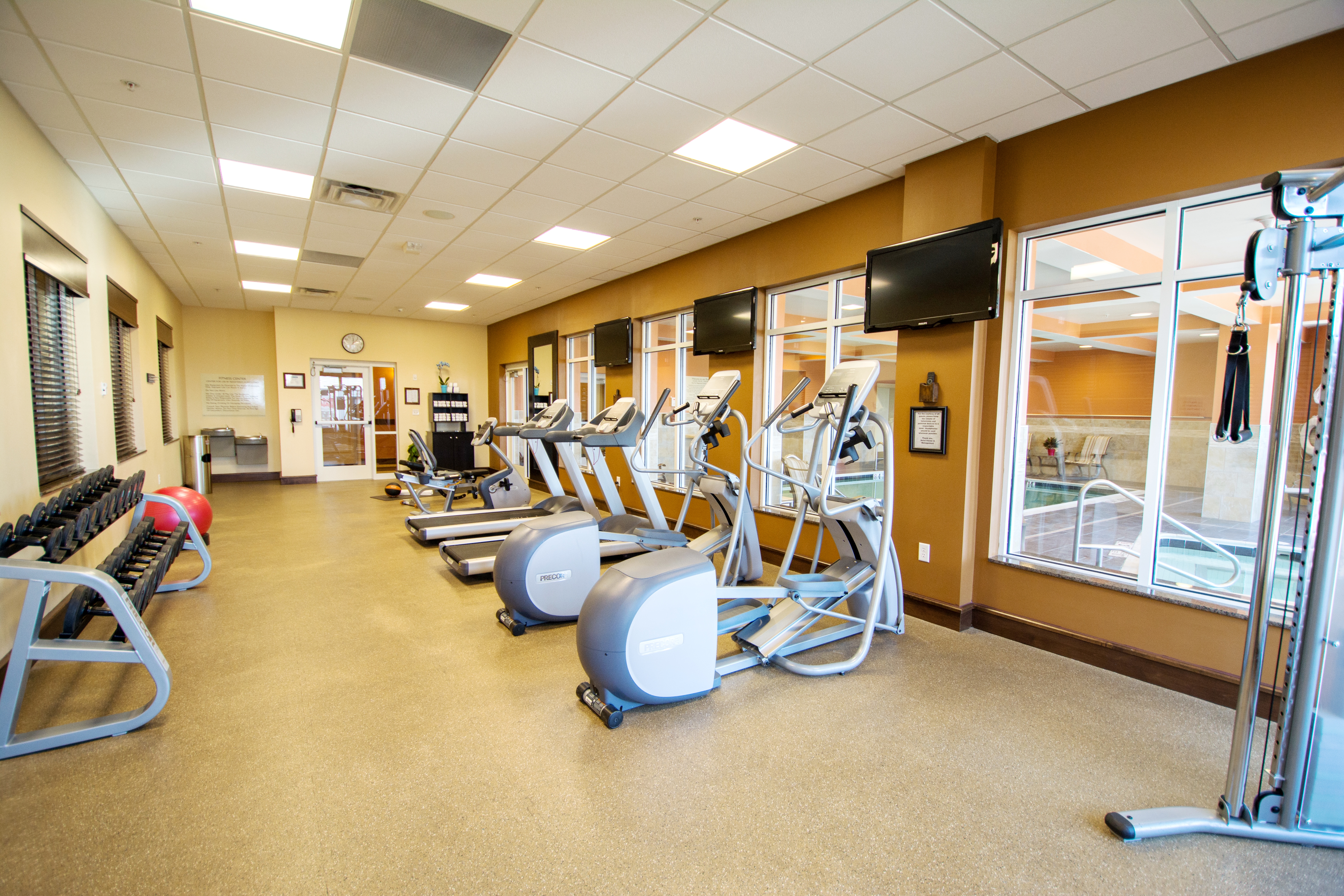 Fitness Center with ellipticals, weights, and other equipment.