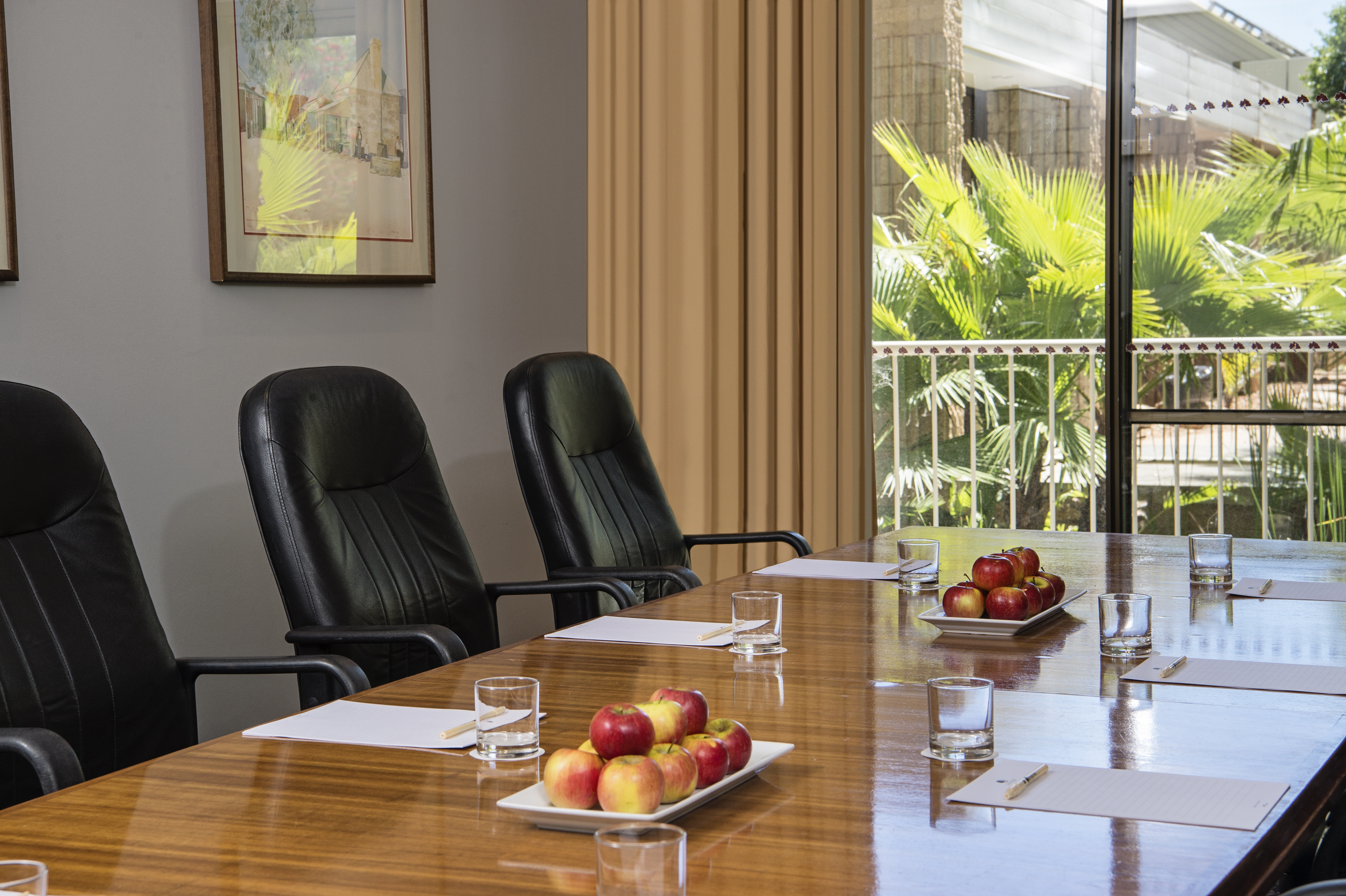 Three Black Chairs at Boardroom Table by Window With Outside View