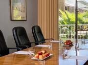 Three Black Chairs at Boardroom Table by Window With Outside View