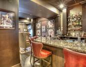 Sports Memorabilia and Red Chairs Around Counter of Fully Stocked Game Changer Bar