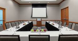Spacious meeting room facility featuring high ceilings, u shape table setup, and podium.