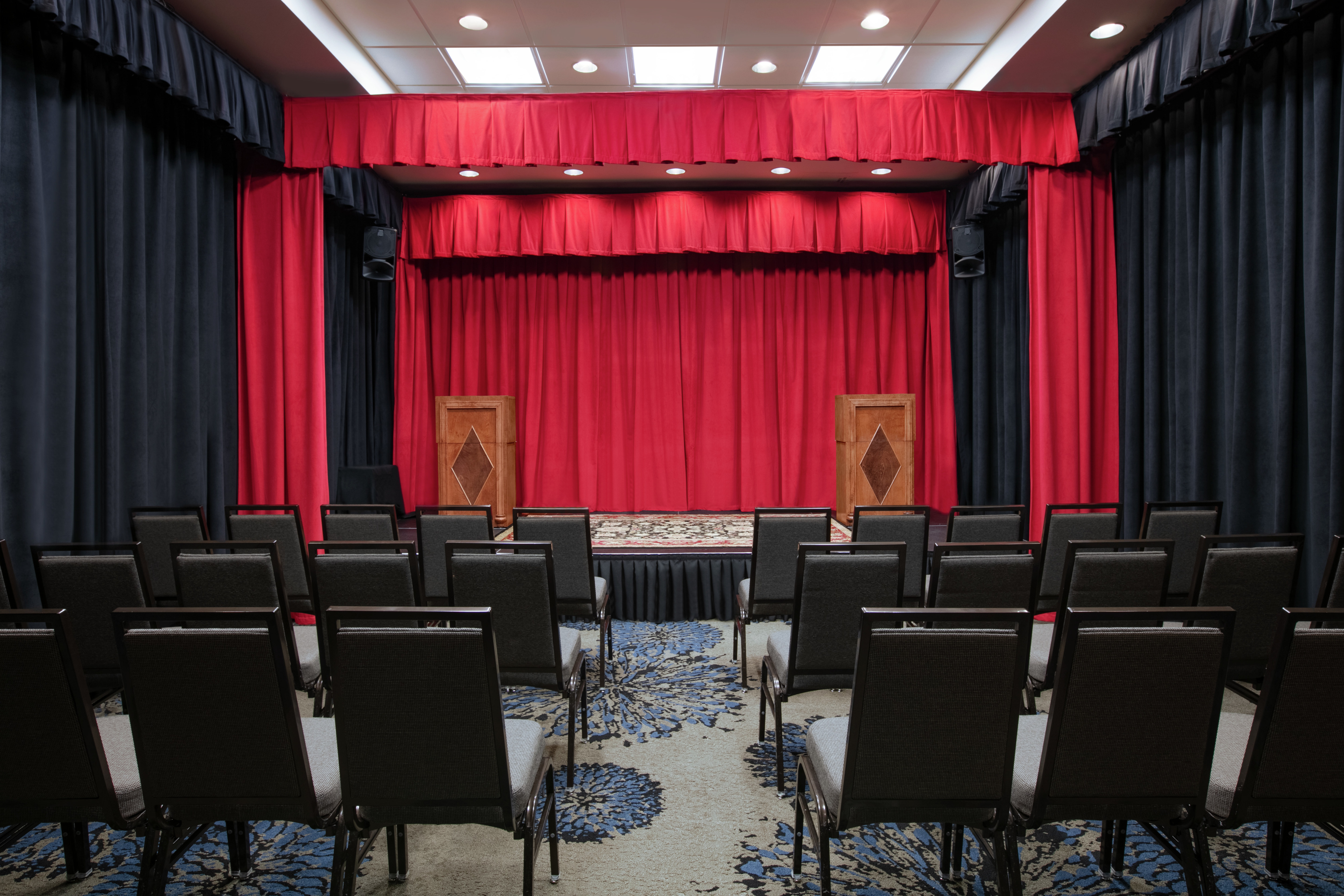 Beautiful theatre facility featuring ample seating, stage, and two podiums.