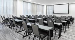Meeting Room Set Up Classroom Style with Tables, Chairs, and Projector Screen