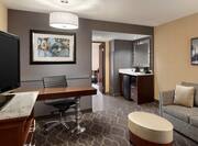 Guest Suite Lounge Area with HDTV, Work Desk, Footrest, Sofa and Beverage Station