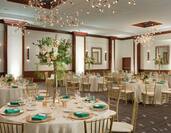 Room set up for a wedding dinner with gold seats and gold decorations
