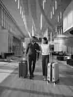 Man and woman walking through lobby area with luggage
