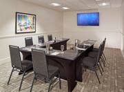 Wall Art and Seating For 8 Around U-Table Facing HDTV in Meeting Room