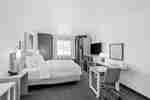 King guest room with bed, desk, television, and contemporary furnishings.