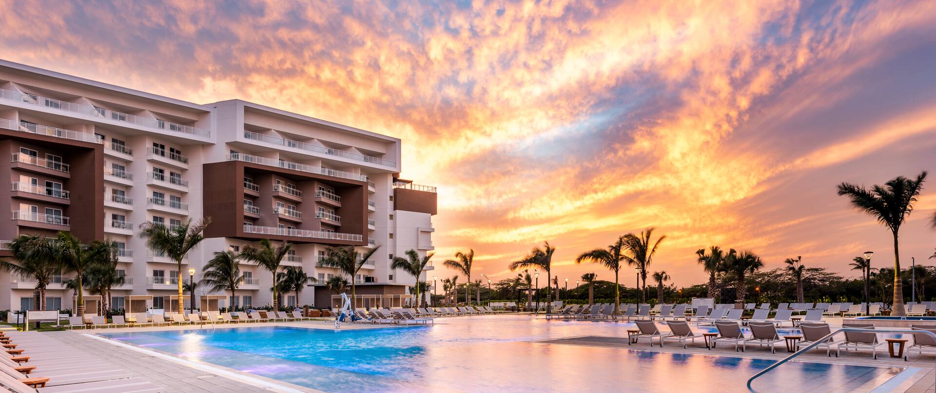 outdoor pool, hotel exterior at sunset