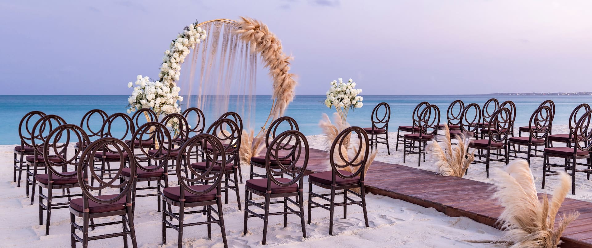 beach wedding ceremony chairs and flower arch
