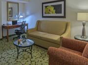 Seating area in accessible suite with couches and work desk.