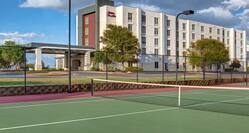 view of hotel exterior and tennis courts 