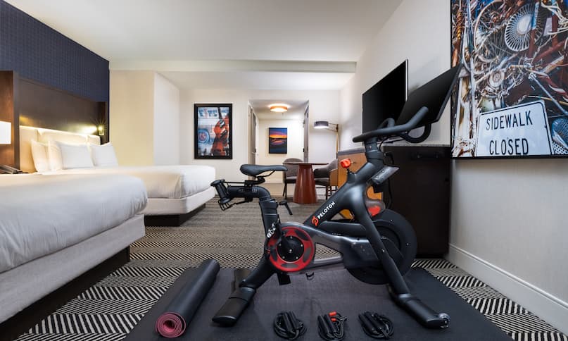 Two Beds in a Room with Peloton Bike and HDTV