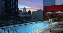 Rooftop Swimming Pool and Lounge Area at Dusk with Sunset View 