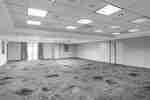 Empty meeting room with patterned carpet and window with curtains 
