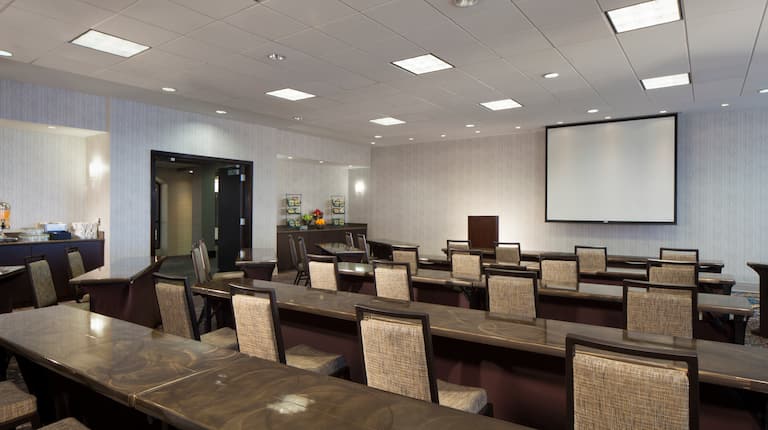 Sala de reuniones tipo aula y pantalla para proyector