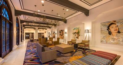 Soft Seating, Decorative Lighting, and Custom Austin Artwork on Walls in Lobby Colonnade
