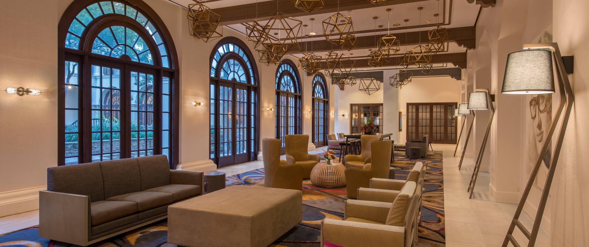 Wide View of Windows, Soft Seating, and Decorative Lighting in Lobby Colonnade Area