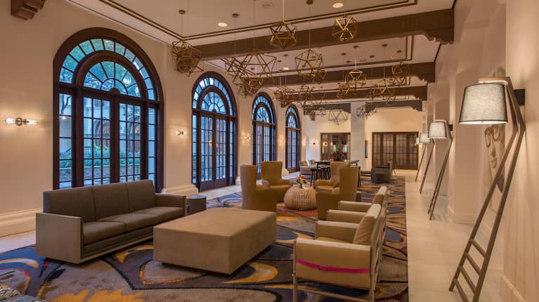 Wide View of Windows, Soft Seating, and Decorative Lighting in Lobby Colonnade Area